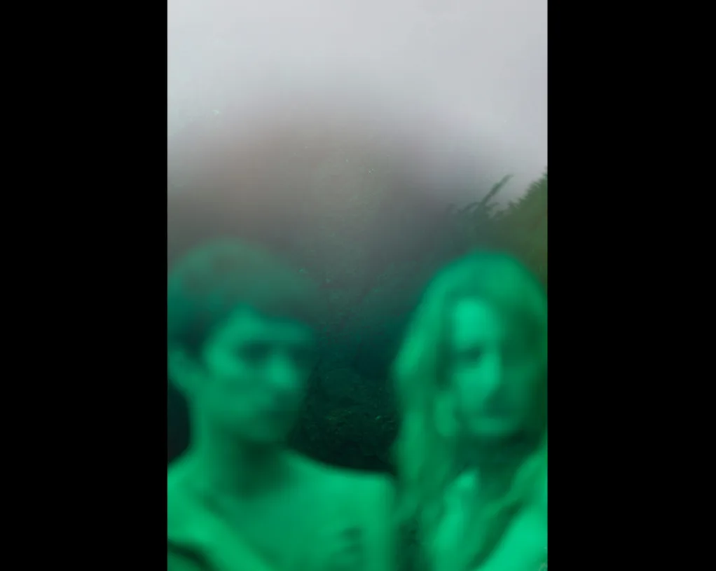 Deux visages flous baignés d'une lumière verte, devant un ciel brumeux, image d'Alice Pallot pour « Algues maudites ».