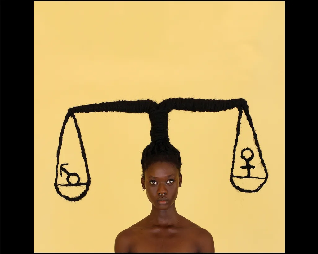 Les tresses d'une jeune femme dressées en balance de la justice, un plateau portant le symbole masculin, l'autre le symbole féminin.