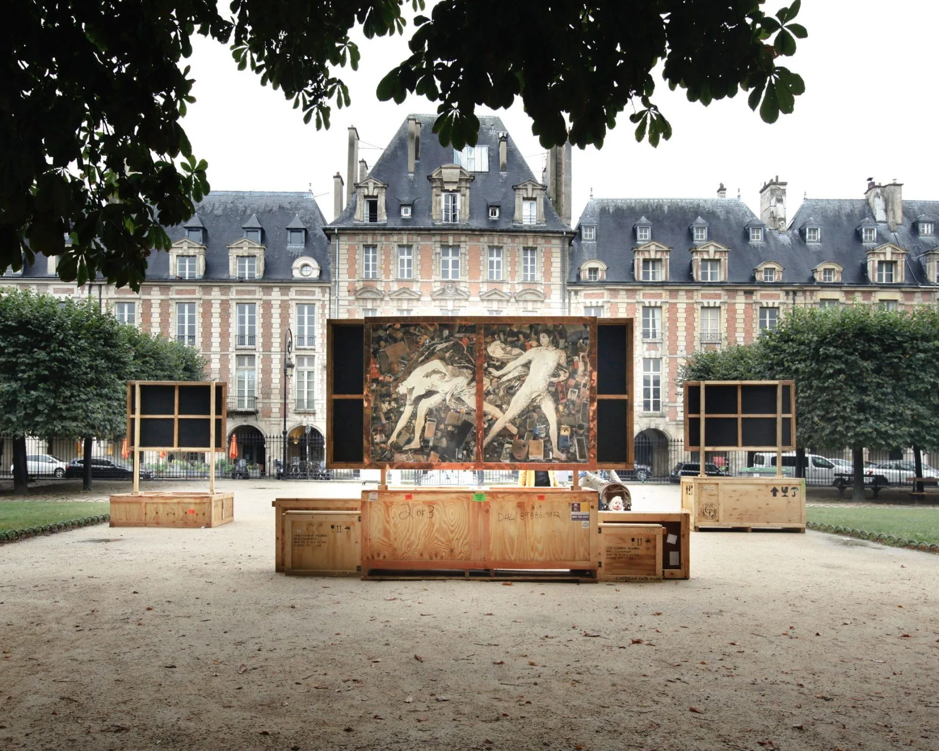 Grande œuvre de Vik Muniz sur un caisson en bois au centre de la place des Vosges, entre les façades de brique et les arbres taillés.
